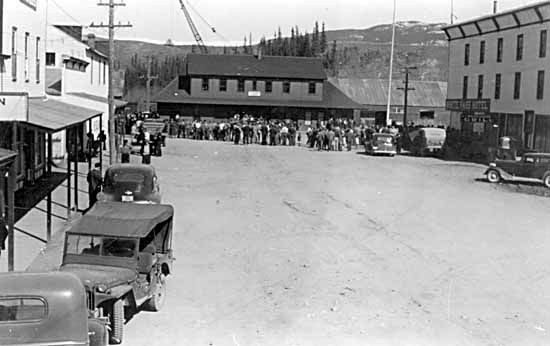 Crowds assembled outside of the Depot at the intersection of Front and Main Streets (c 1942)